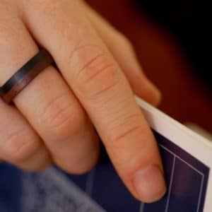 Model wearing wooden ring while turning a page of a book